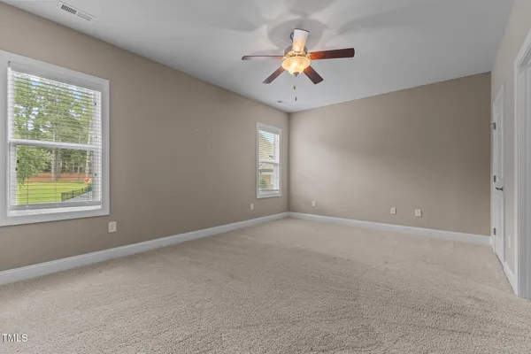an empty room with a window and a fan