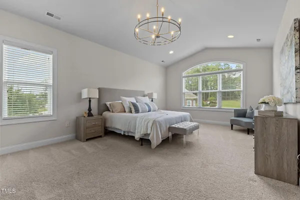 a bathroom with a granite countertop double vanity sink a mirror and a shower