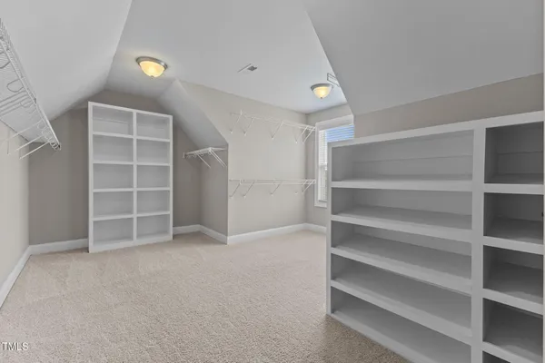 a view of an empty room with a chandelier fan