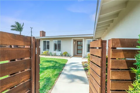 a view of a house with backyard and wooden fence