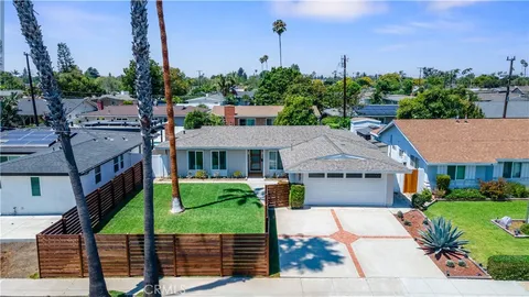 a aerial view of a house with a yard table and chairs