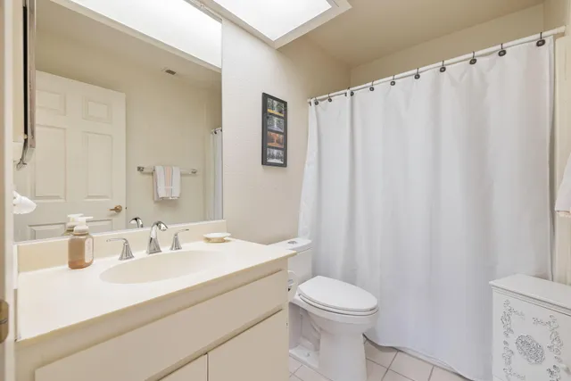 a bathroom with a sink a toilet and shower curtain