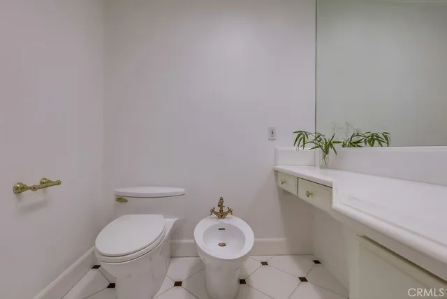 a bathroom with a granite countertop toilet and a sink