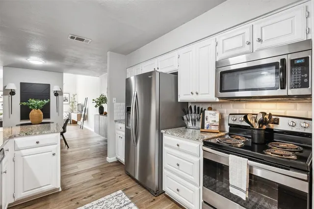 a kitchen with stainless steel appliances a stove microwave and refrigerator