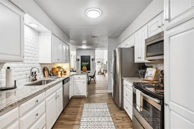 a kitchen with a sink stainless steel appliances and cabinets
