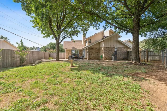 a view of a yard in front of a house with large tree