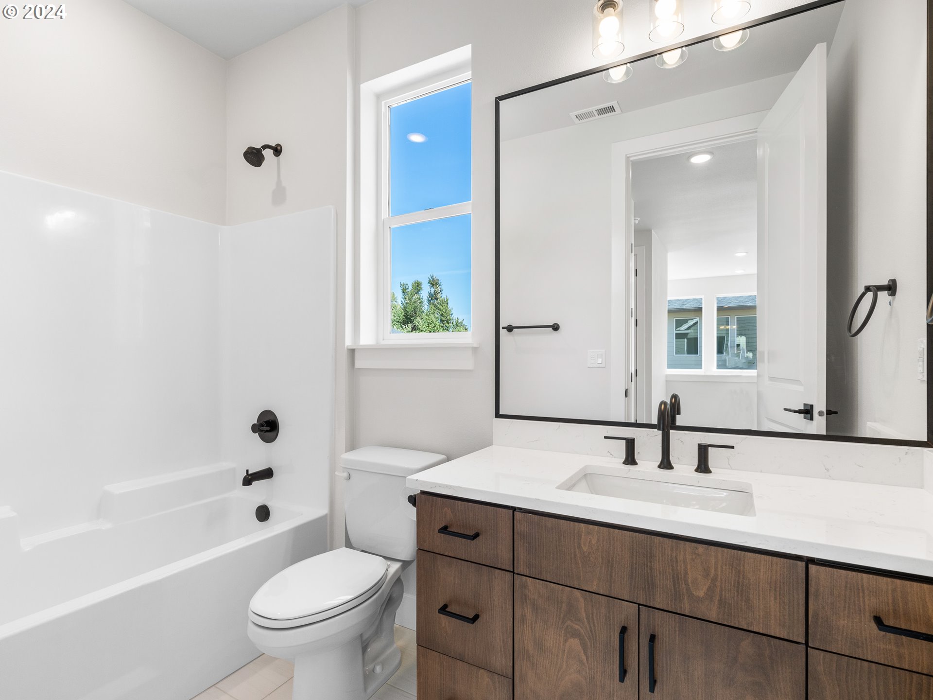 16911 Southeast Siri Loop Damascus, OR 97089 - Photo 15 of 21 a bathroom with a sink toilet a large mirror a bathtub and shower