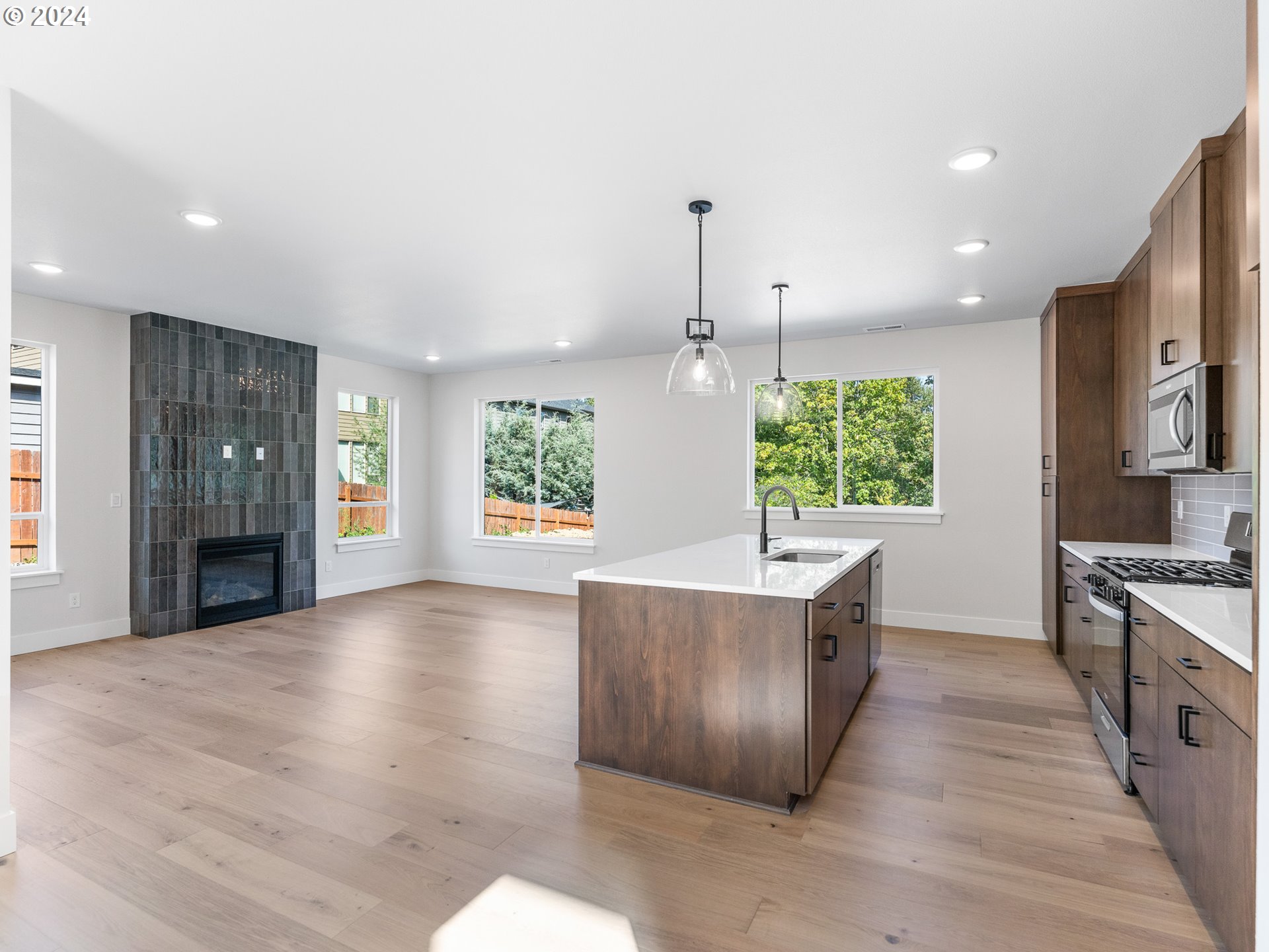 16911 Southeast Siri Loop Damascus, OR 97089 - Photo 5 of 21 a large kitchen with stainless steel appliances granite countertop a refrigerator a sink dishwasher a oven and a dining table with wooden floor