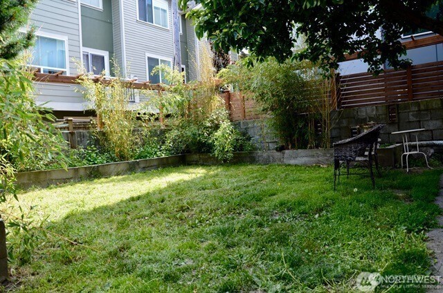 1409 Northwest 65th Street, Unit 3 Seattle, WA 98117 - Photo 21 of 23 a view of a backyard with plants and a bench