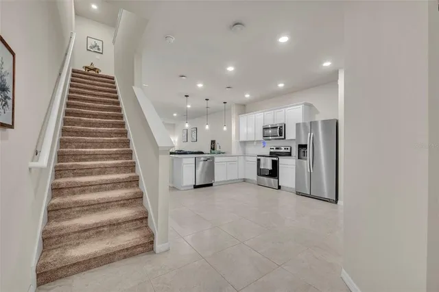 a large white kitchen with kitchen island a stove a sink and a microwave