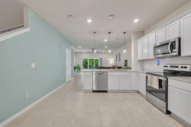 a large kitchen with stainless steel appliances kitchen island a large counter top and a stove top oven