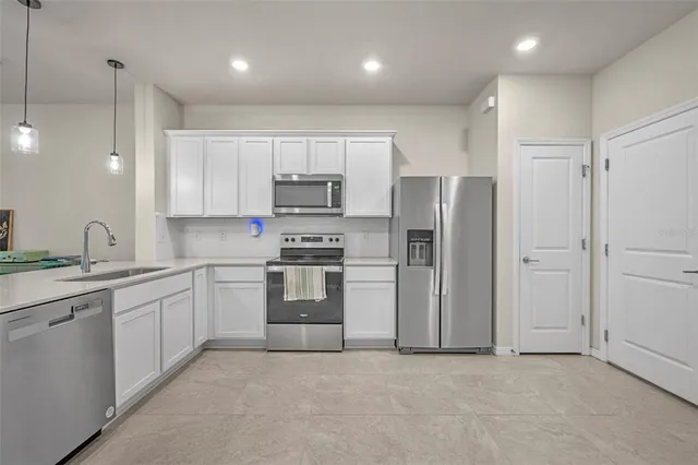 a kitchen with stainless steel appliances kitchen island granite countertop a table and chairs in it