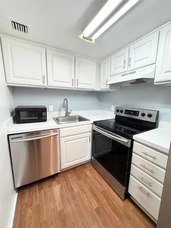 a kitchen with granite countertop white cabinets and white appliances