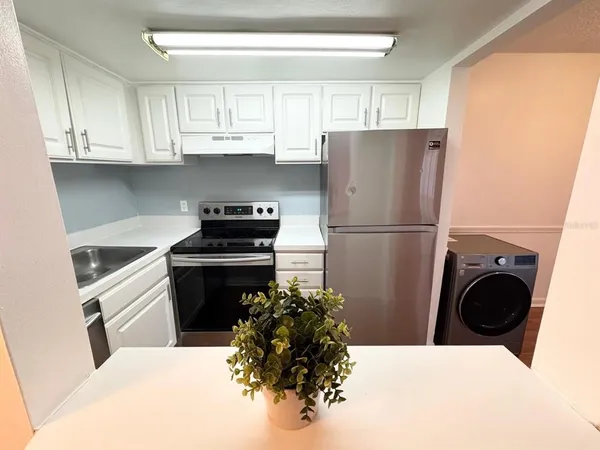a kitchen with a refrigerator and a stove top oven