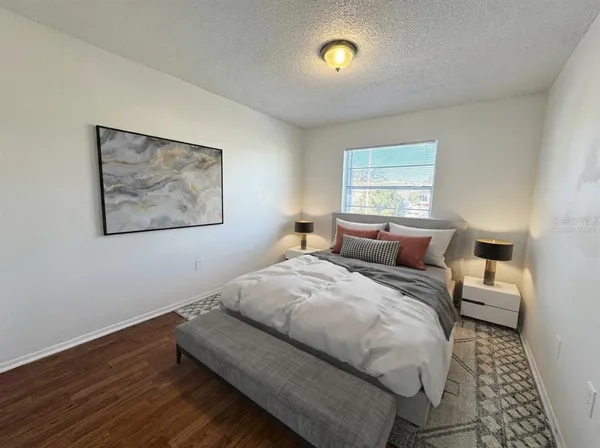 a bed room with bed and a painting on the wall