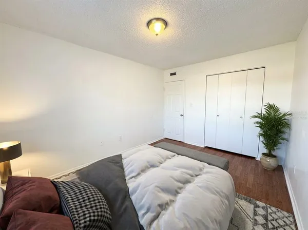 a bedroom with a bed and a potted plant