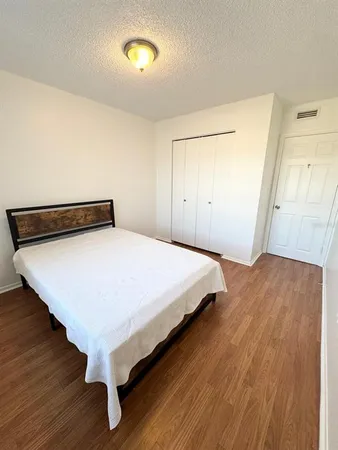 a bedroom with a bed and wooden floor