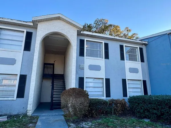 a front view of a house with garden and flowers