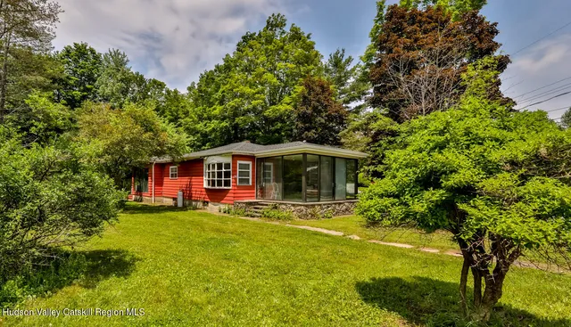 a front view of a house with yard and green space