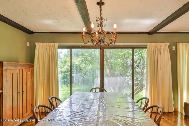a living room with furniture large windows and wooden floor