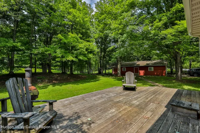 a wooden bench sitting in a park with large trees