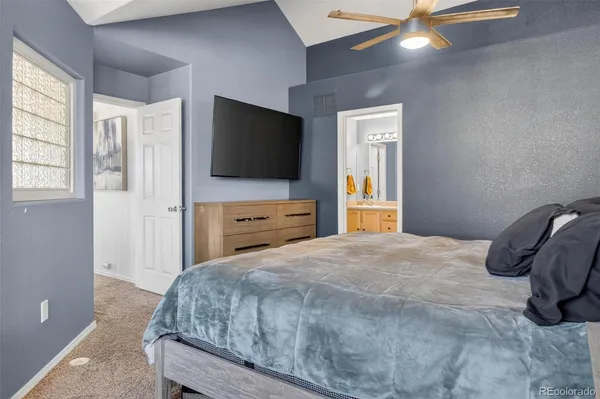 a bedroom with a bed and a flat tv screen on dresser