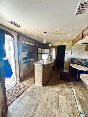 a kitchen with stainless steel appliances kitchen island granite countertop a refrigerator and a stove