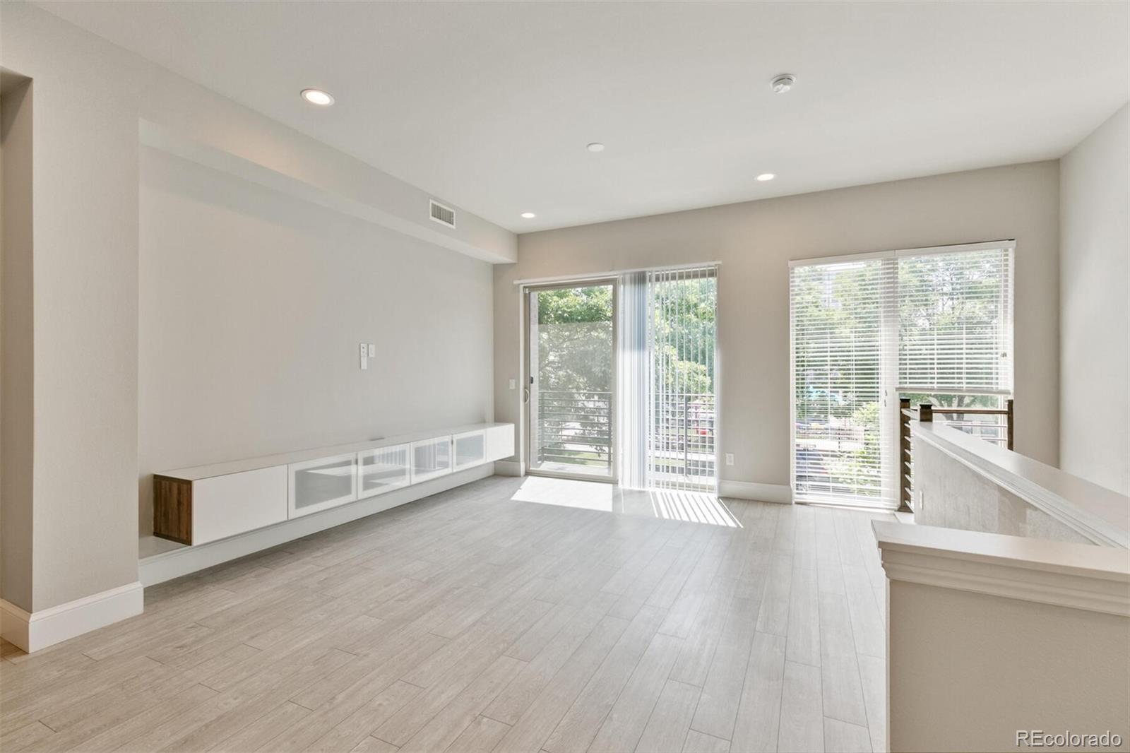 1014 Acoma Street Denver, CO 80204 - Photo 11 of 35 a view of an empty room with wooden floor and a window
