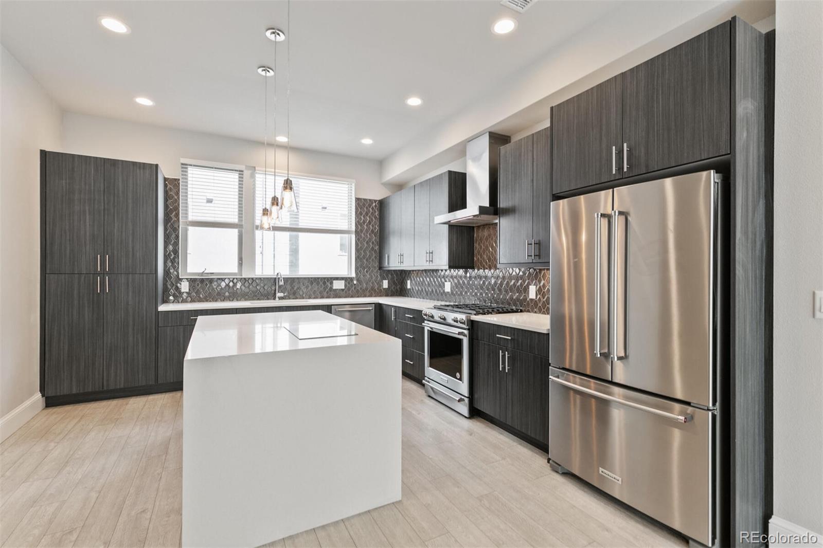 1014 Acoma Street Denver, CO 80204 - Photo 15 of 35 a kitchen with stainless steel appliances granite countertop a refrigerator stove microwave and sink