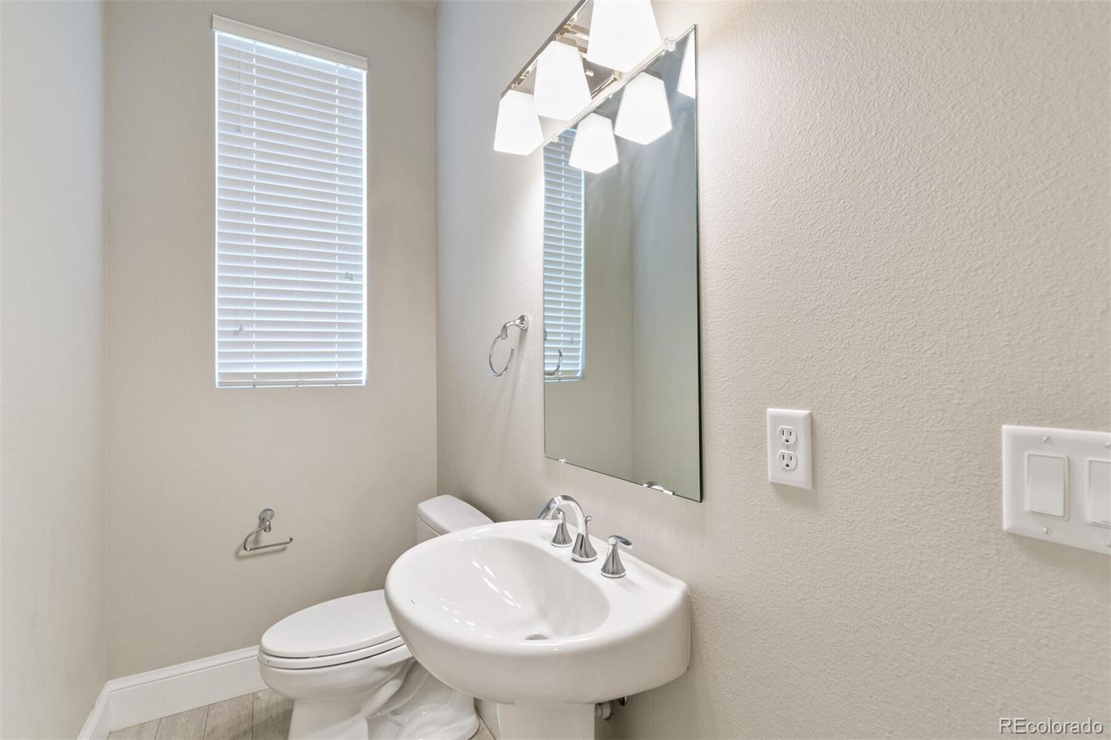 1014 Acoma Street Denver, CO 80204 - Photo 18 of 35 a bathroom with a sink a toilet and mirror
