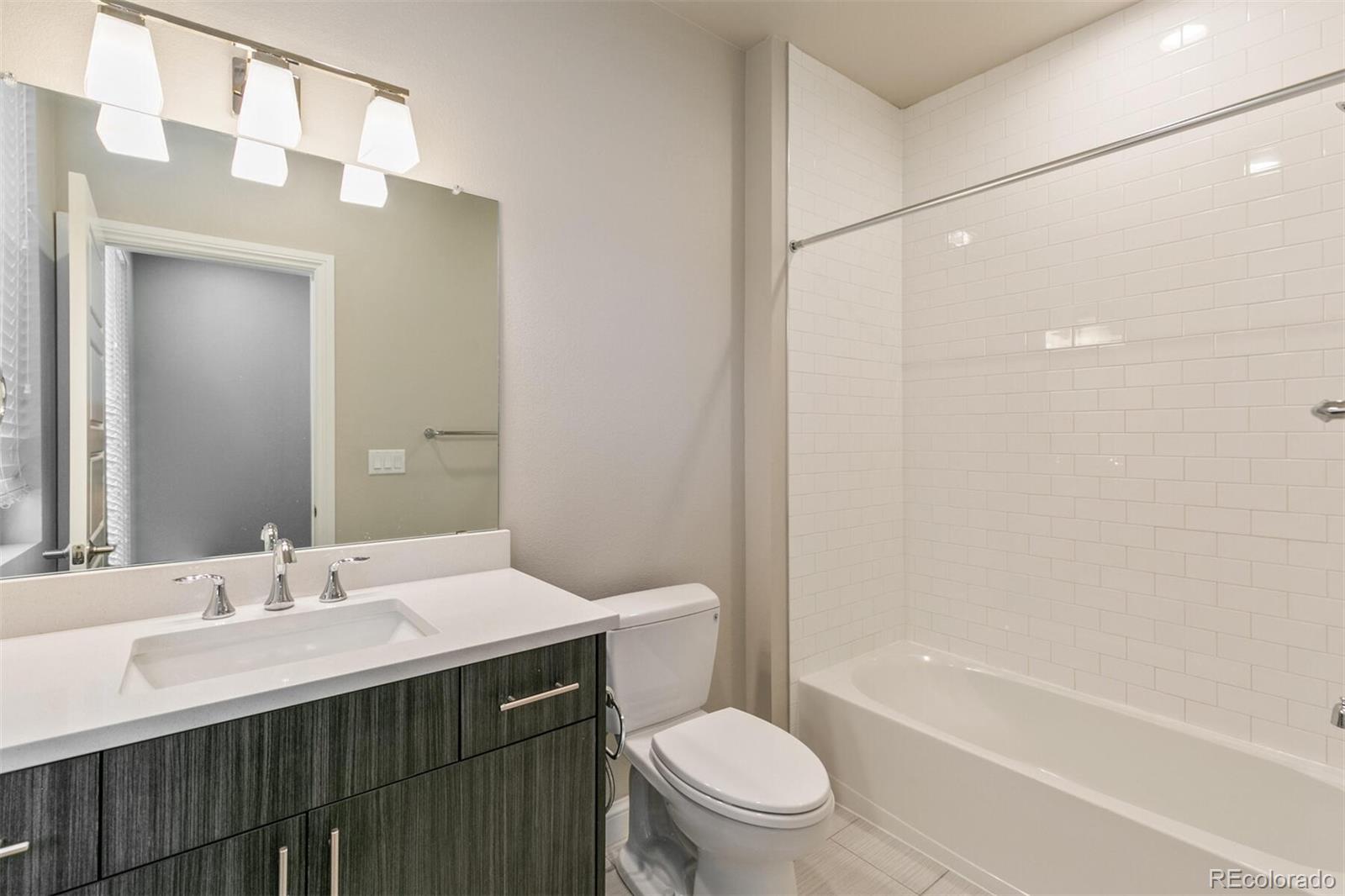 1014 Acoma Street Denver, CO 80204 - Photo 26 of 35 a bathroom with a sink toilet vanity and shower