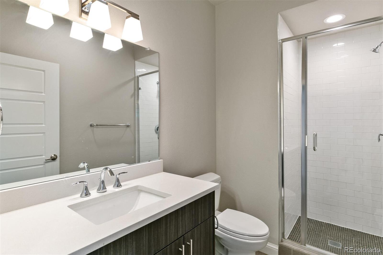 1014 Acoma Street Denver, CO 80204 - Photo 8 of 35 a bathroom with a sink a toilet a mirror and vanity
