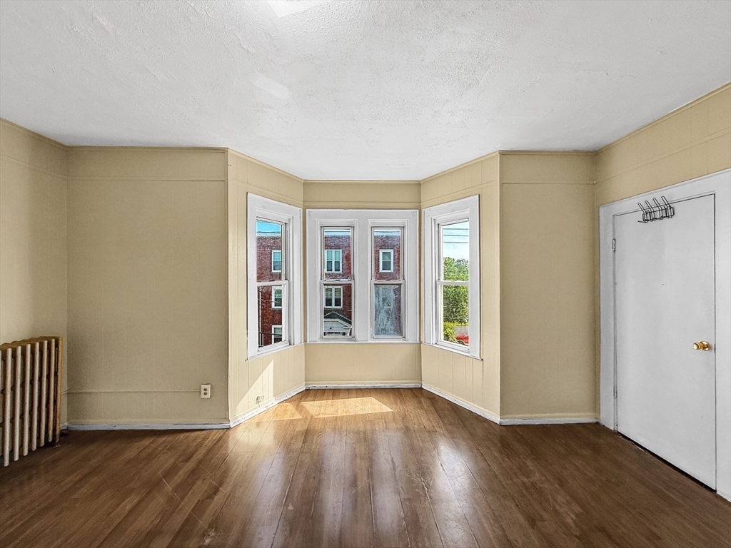 19 High Street Lynn, MA 01902 - Photo 15 of 42 a view of an empty room with wooden floor and a window