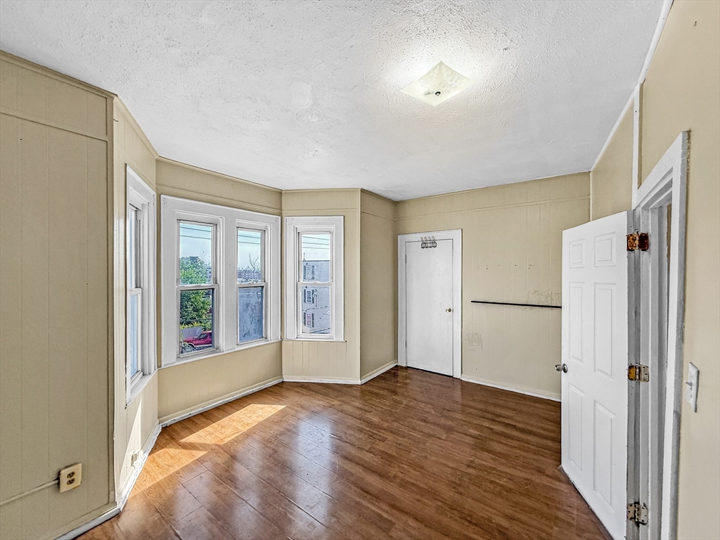 19 High Street Lynn, MA 01902 - Photo 16 of 42 a view of an empty room with wooden floor and a window