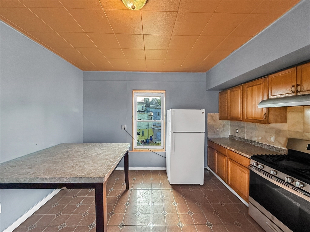 19 High Street Lynn, MA 01902 - Photo 21 of 42 a kitchen with a refrigerator a stove and a sink