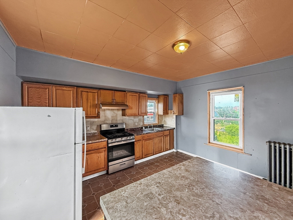 19 High Street Lynn, MA 01902 - Photo 23 of 42 a kitchen with a refrigerator and a stove top oven