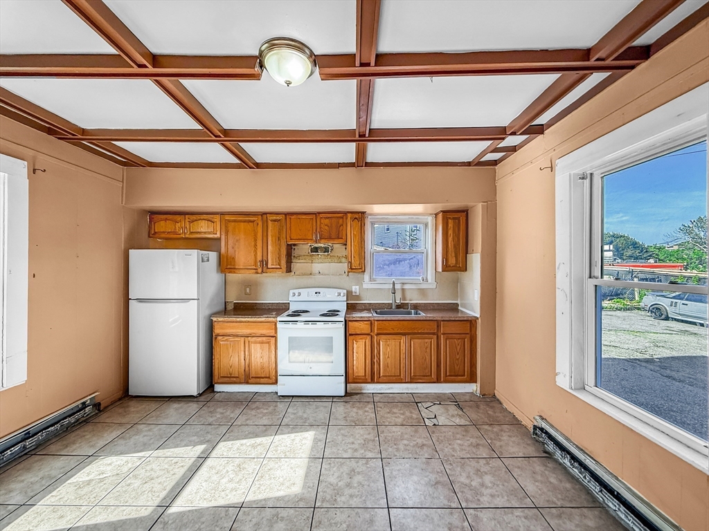 19 High Street Lynn, MA 01902 - Photo 6 of 42 a kitchen with stainless steel appliances granite countertop a sink and a refrigerator