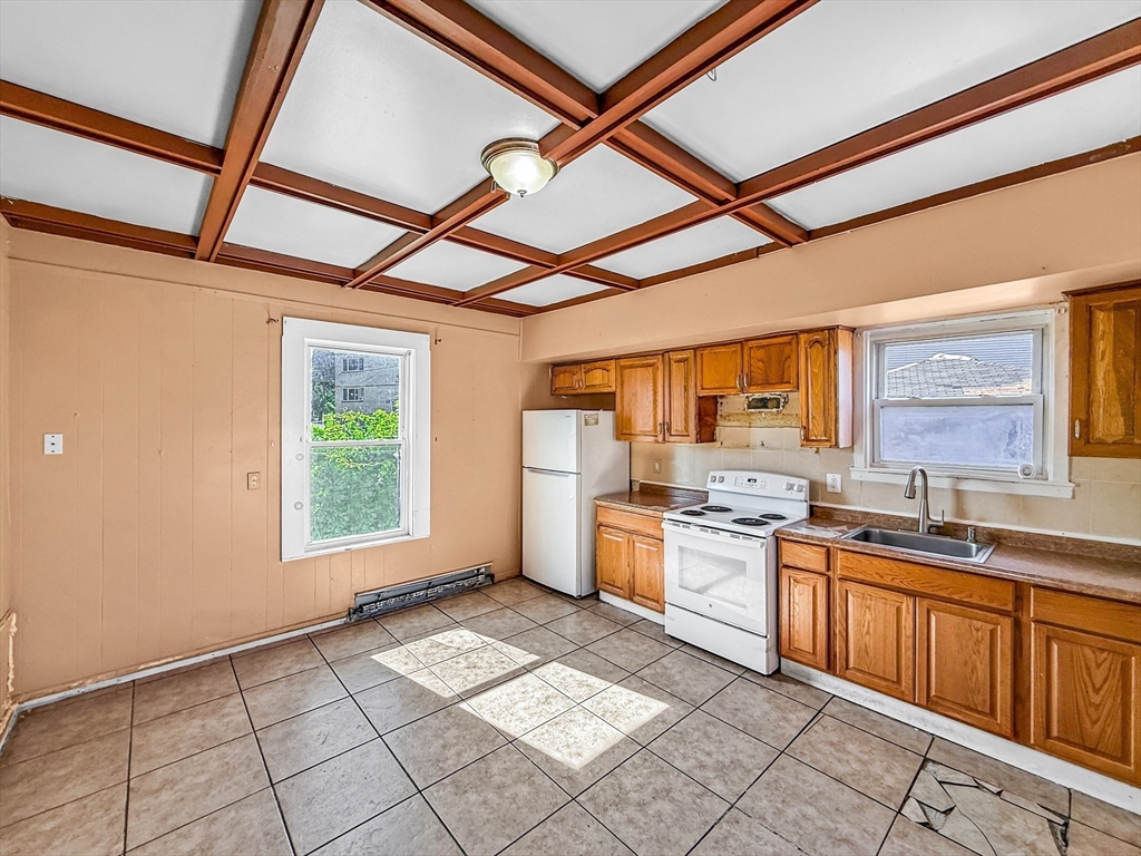19 High Street Lynn, MA 01902 - Photo 7 of 42 a kitchen with a stove a sink and a refrigerator