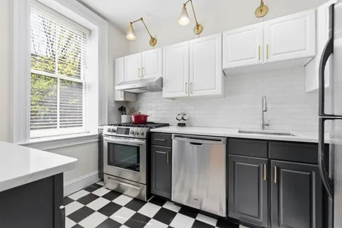 a kitchen with stainless steel appliances a sink stove and cabinets