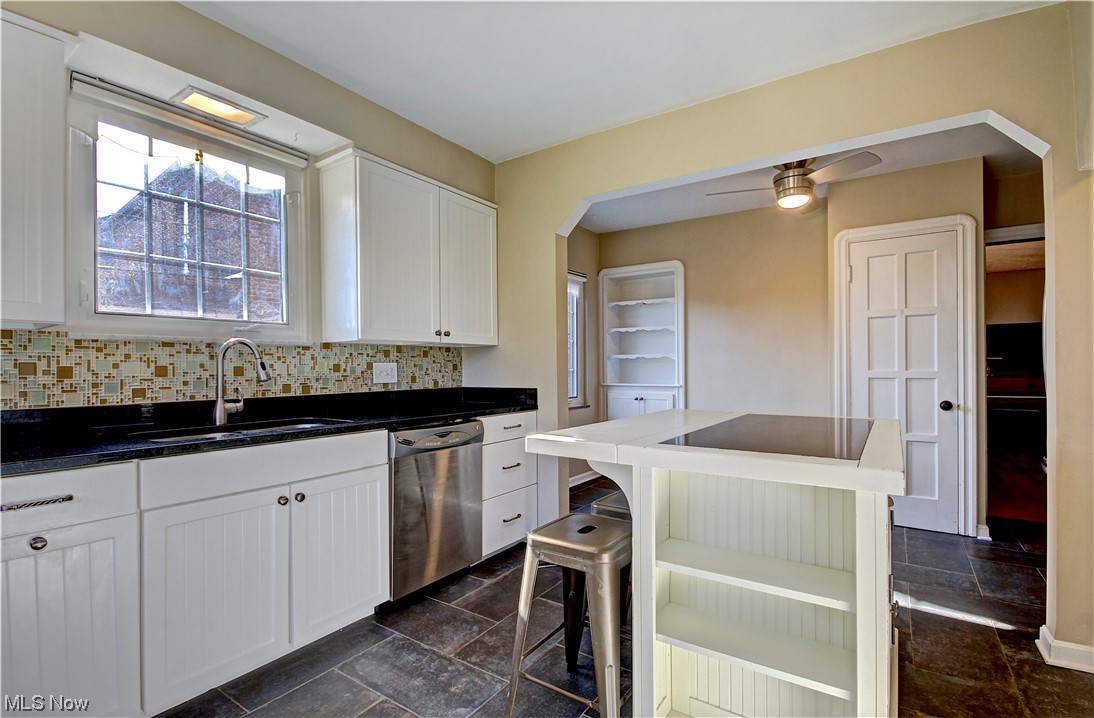 3717 Warren Road Cleveland, OH 44111 - Photo 19 of 50 Kitchen featuring dark tile floors, ceiling fan, backsplash, and stainless steel dishwasher
