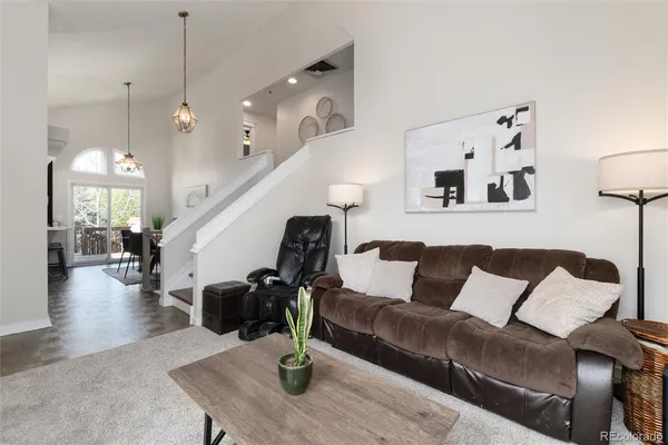 a living room with furniture flowerpot and wooden floor