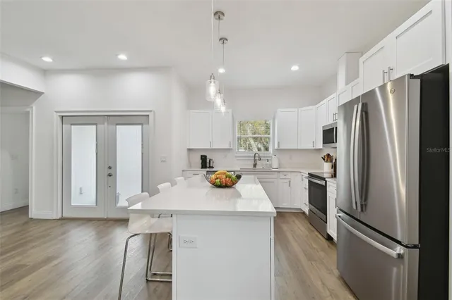 a kitchen with refrigerator and white cabinets