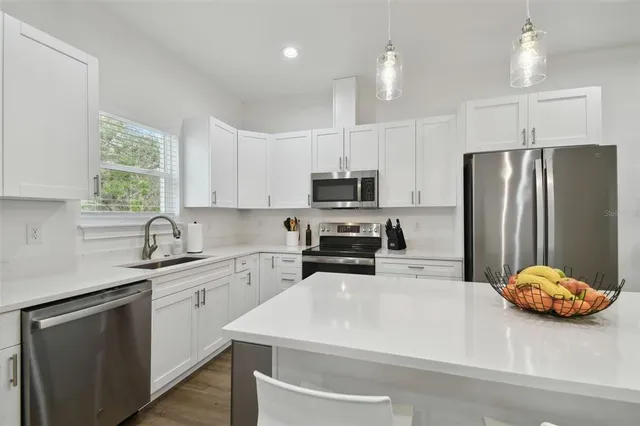a kitchen with stainless steel appliances a refrigerator sink and microwave
