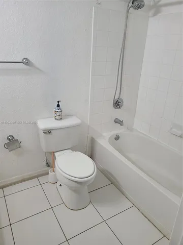 a white toilet sitting next to a bath tub