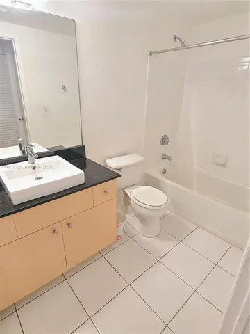 a bathroom with a granite countertop sink a toilet and a mirror