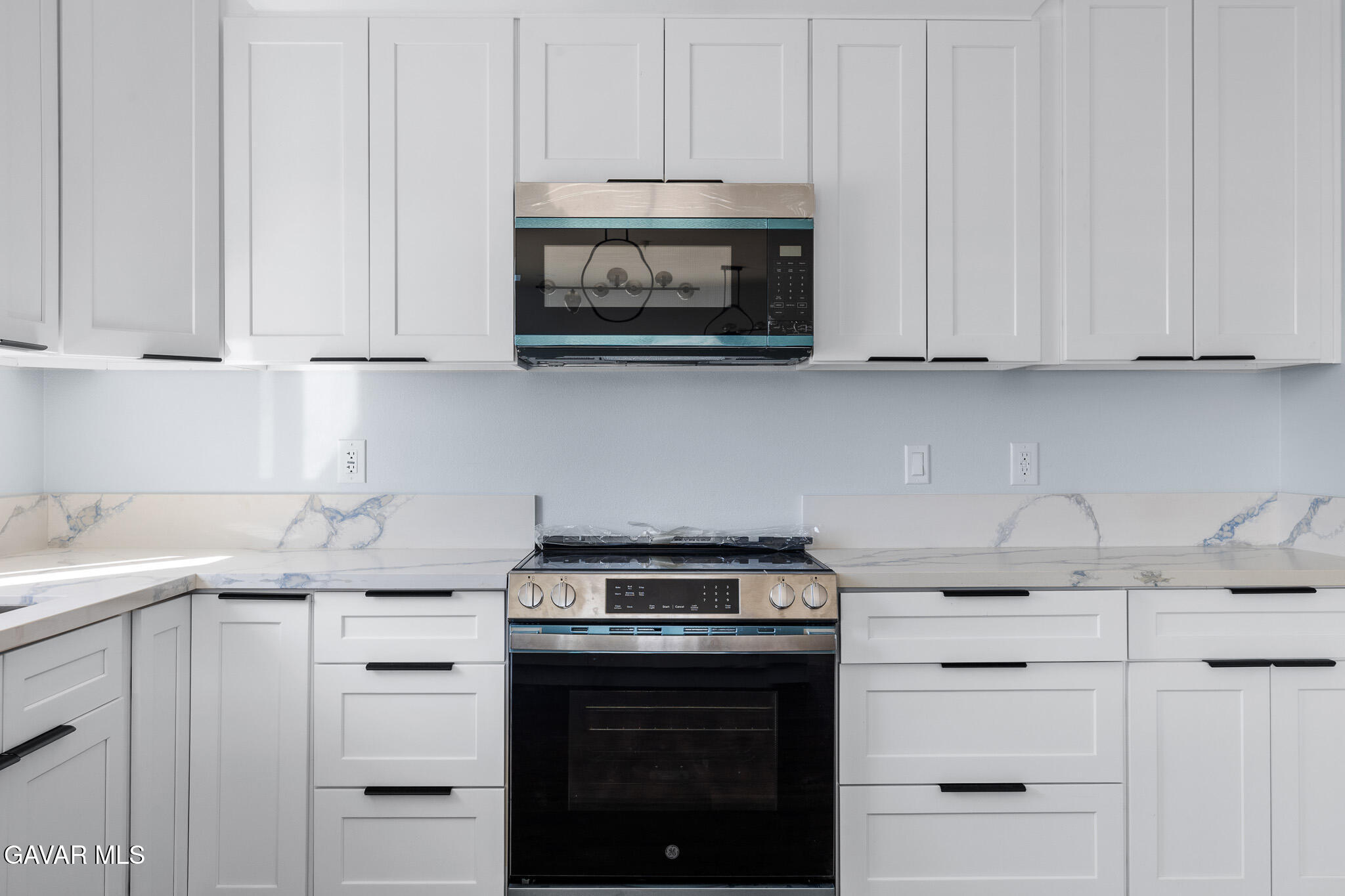 10708 East Ave R 14 Littlerock, CA 93543 - Photo 11 of 38 a kitchen with granite countertop white cabinets and stainless steel appliances