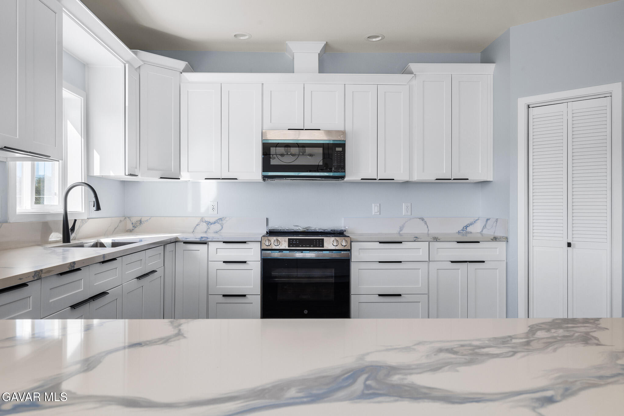 10708 East Ave R 14 Littlerock, CA 93543 - Photo 15 of 38 a kitchen with appliances a sink and cabinets