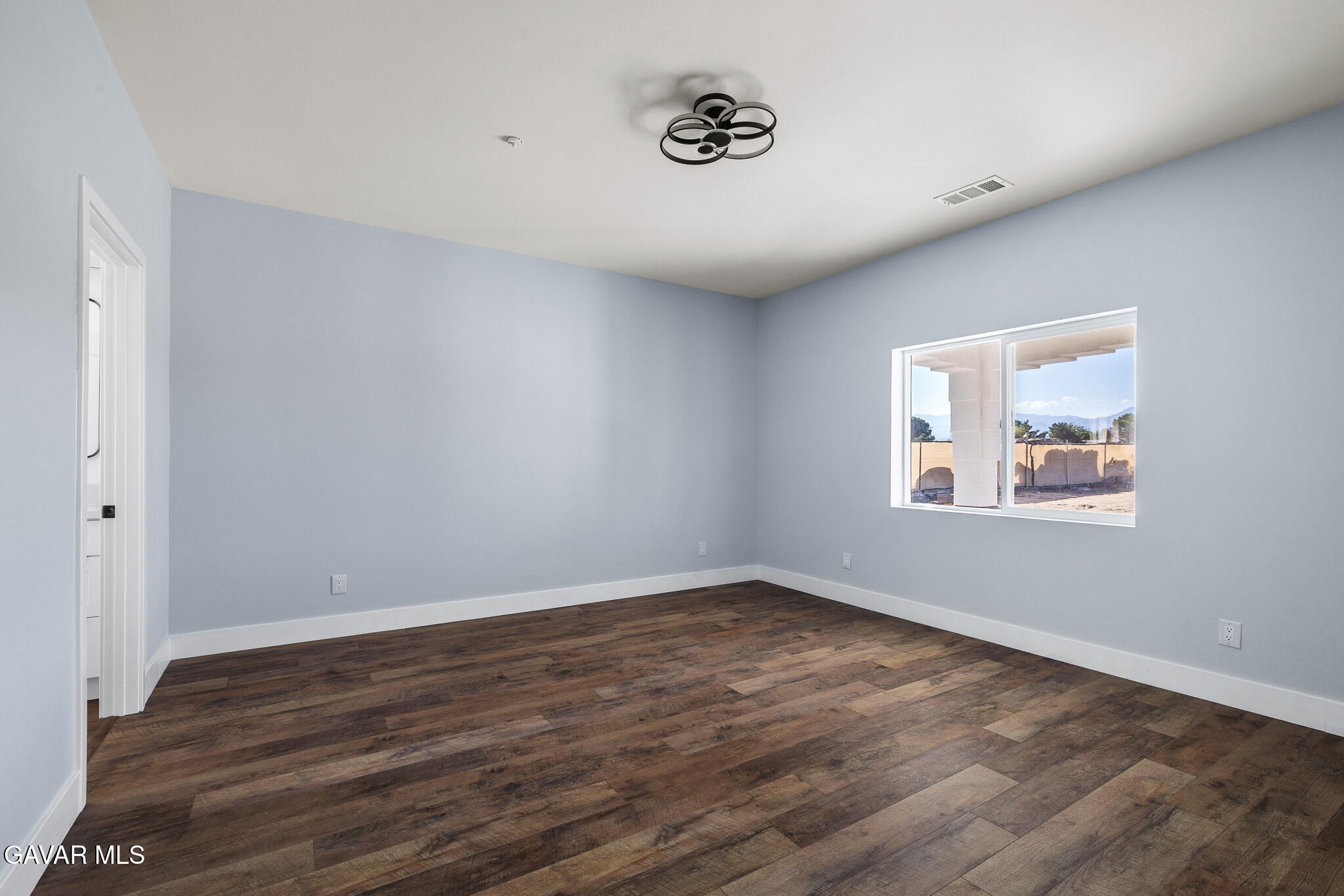 10708 East Ave R 14 Littlerock, CA 93543 - Photo 18 of 38 a view of an empty room with wooden floor and a window
