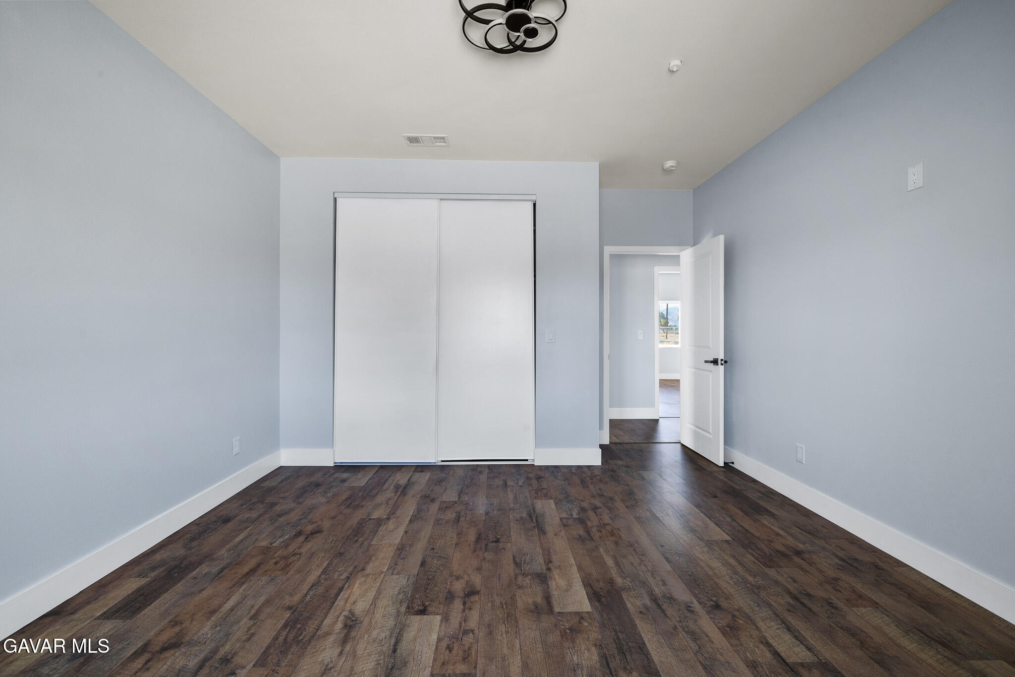 10708 East Ave R 14 Littlerock, CA 93543 - Photo 25 of 38 a view of an empty room with wooden floor and a window