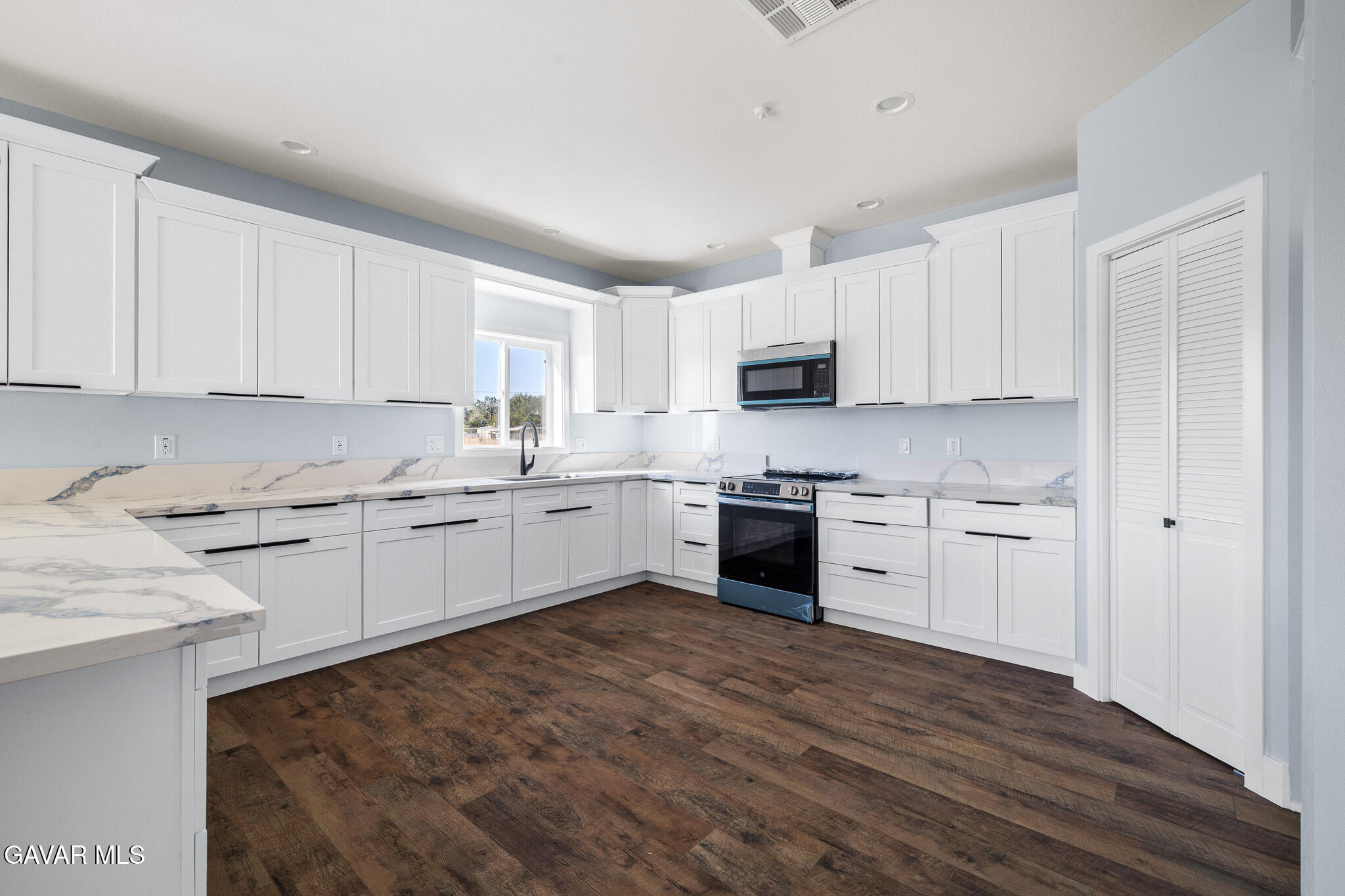 10708 East Ave R 14 Littlerock, CA 93543 - Photo 9 of 38 a kitchen with granite countertop white cabinets and white appliances